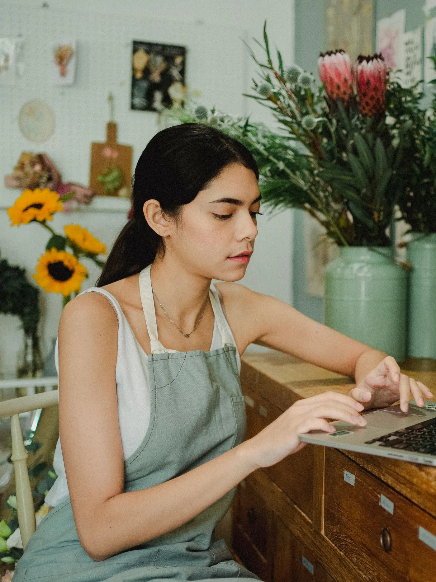 A flower shop owner working on a laptop at her counter